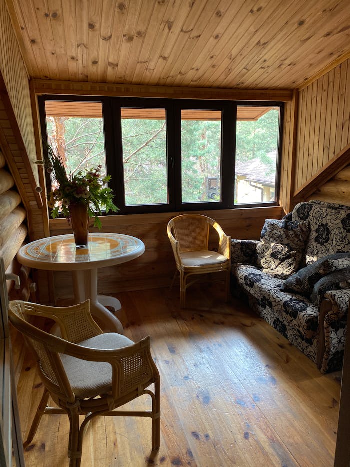 services-06 Warm and inviting wooden attic room with classic rustic furniture and a scenic window view.